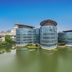Wuxi Idea Garden Hotel in Wuxi, a modern glass hotel beside a calm lake under a clear blue sky