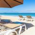 Seascape Hotel in Providenciales beach scene with lounge chairs, umbrellas and turquoise ocean