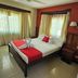 Caye Caulker Plaza Hotel room in Caye Caulker with bed, red accents, and large windows