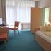 Room at Gesundheitshotel Das Bad Peterstal in Bad Peterstal-Griesbach with twin bed, desk and chair