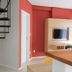 The World Indaiatuba room with spiral staircase, wall-mounted TV, and red accent wall