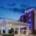 Holiday Inn Express & Suites Dumas By IHG exterior at dusk with purple-lit facade and covered entrance