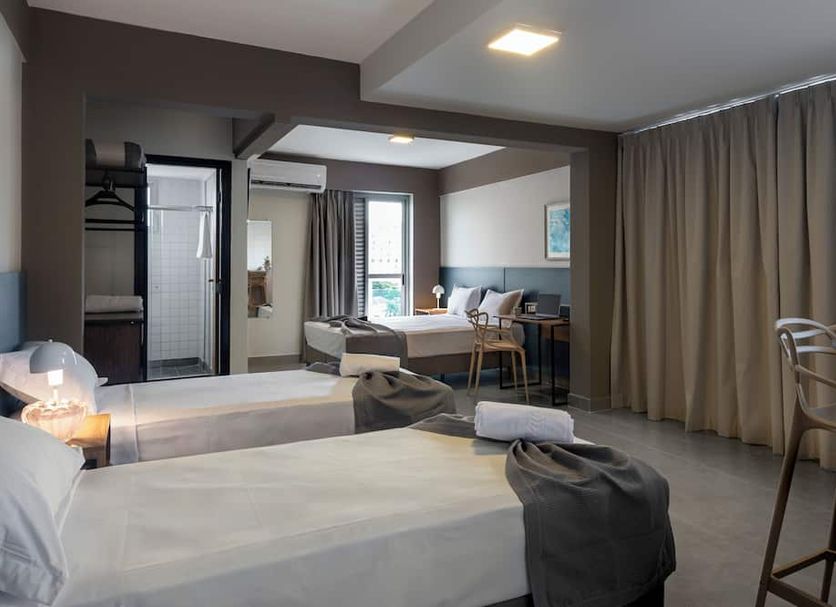 Lym Flat Hotel in Uberlândia with twin beds, desk, seating area and floor-to-ceiling curtains