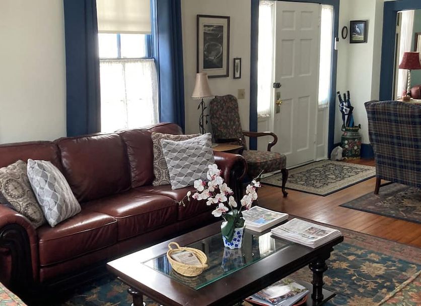 Terrell House B&B in Burnsville living room with leather sofa, coffee table, chair, and hardwood floors