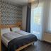 Hotel am Kurpark in Bad Lauterberg guest room with twin bed, patterned accent wall and balcony door