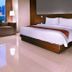 Aston Imperial Bekasi Hotel & Conference Center room with city view, bed, sofa and floor lamp in Bekasi