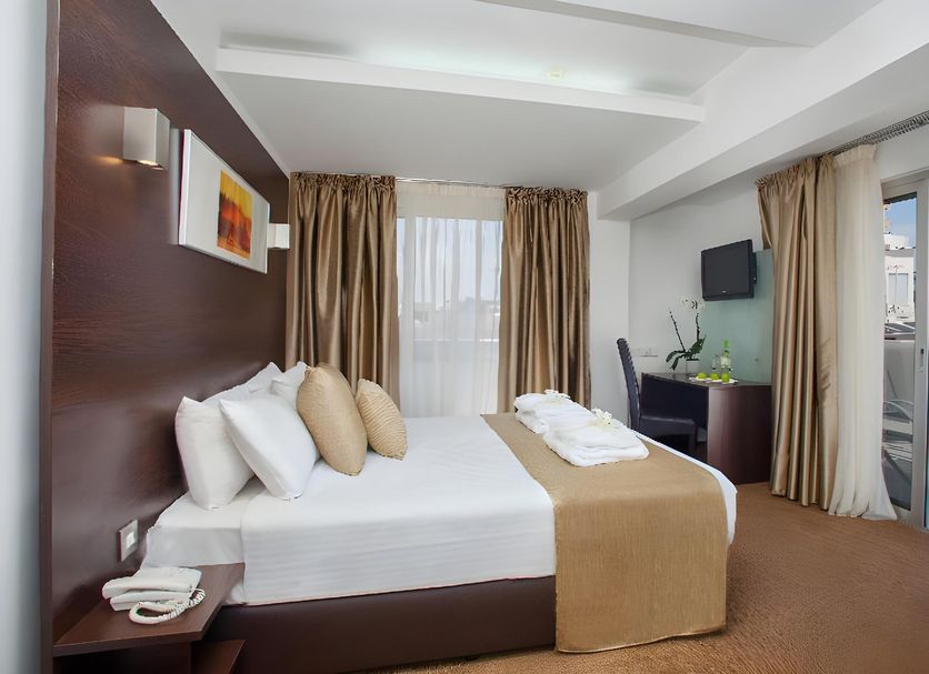 Amorgos Boutique Hotel Larnaca guest room with king bed, balcony sea view, and seating area
