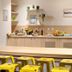Teneo Apparthotel Bordeaux Maritime breakfast room with buffet counter and yellow stools in Bordeaux