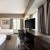 The Mosey Buffalo Williamsville guest room with two beds, desk, and wall-mounted TV in Williamsville