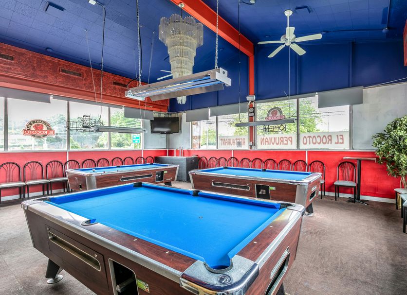 Red Carpet Inn - Stamford game room with blue pool tables, red chairs and blue ceiling