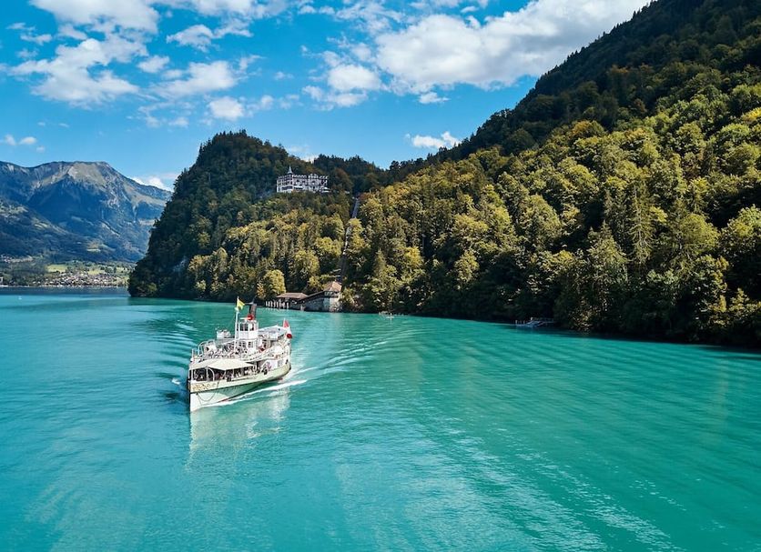 Grandhotel Giessbach, Brienz: boat on turquoise lake beside forested mountains