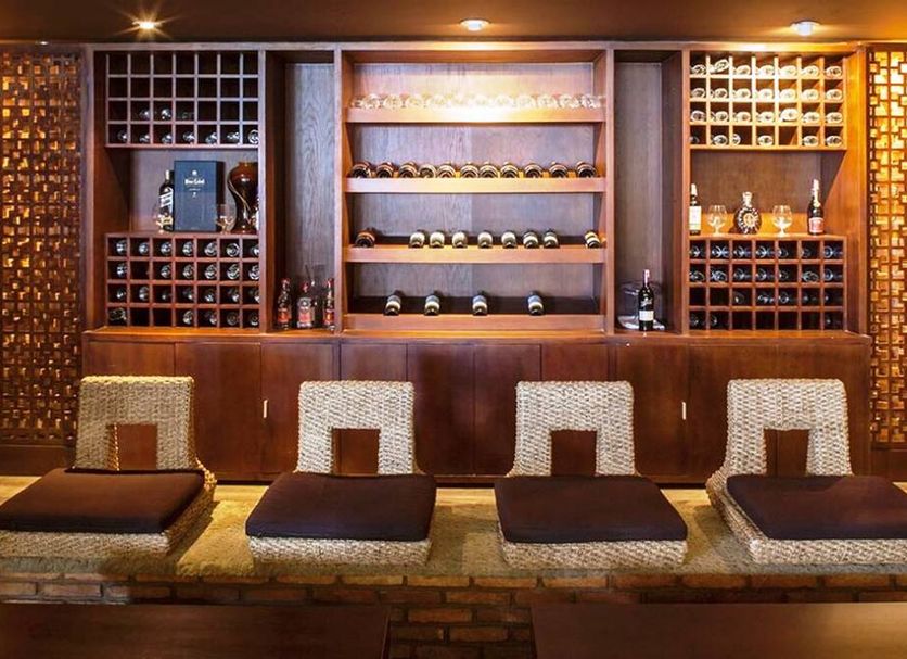 Aroma Beach Resort And Spa in Phan Thiet lounge with woven floor cushions and wood wine display