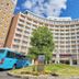 Toyoko Inn Narita Airport Honkan in Narita with curved facade, landscaped entrance, and blue shuttle bus