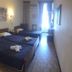 Gythion Hotel in Gytheio guest room with two beds, bedside lamps, and a bright window at the far end.