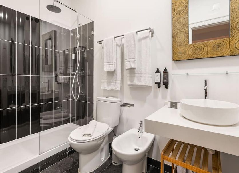 Casa do Bairro by Shiadu bathroom with glass shower, toilet, bidet and vanity in Lisbon