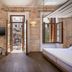 Ambassadors Residence Boutique Hotel in Chania room with open balcony doors and stone walls