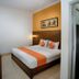 Hotel Poncowinatan - Tugu room in Yogyakarta with double bed, orange accents and wall-mounted TV