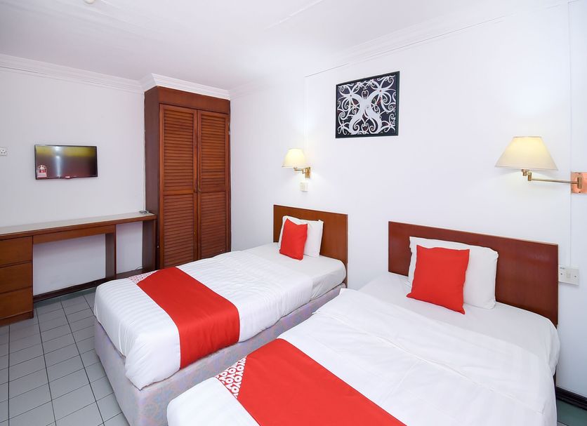 Super OYO 1018 Telang Usan Hotel Miri room with two twin beds and wall lamps