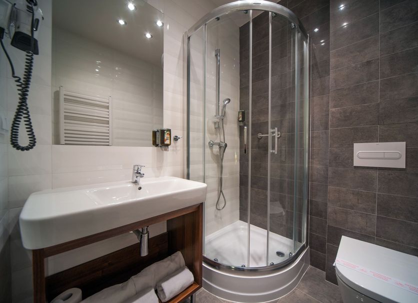 Hotel Kazimierzówka in Kazimierz Dolny bathroom with glass corner shower and wall-mounted sink