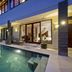 Sahaja Sawah Resort Tabanan villa with private pool and patio beside glass doors at dusk