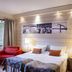 Lapland Hotels Riekonlinna Saariselka room with twin beds, red armchair, lamps and forest-view window