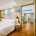 Shama Petchburi 47 Bangkok guest room with king bed, wood floors, and city-view window