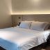 The Imperial Hotel, Kluang: double bed in a simple guest room with bedside tables and wall lighting