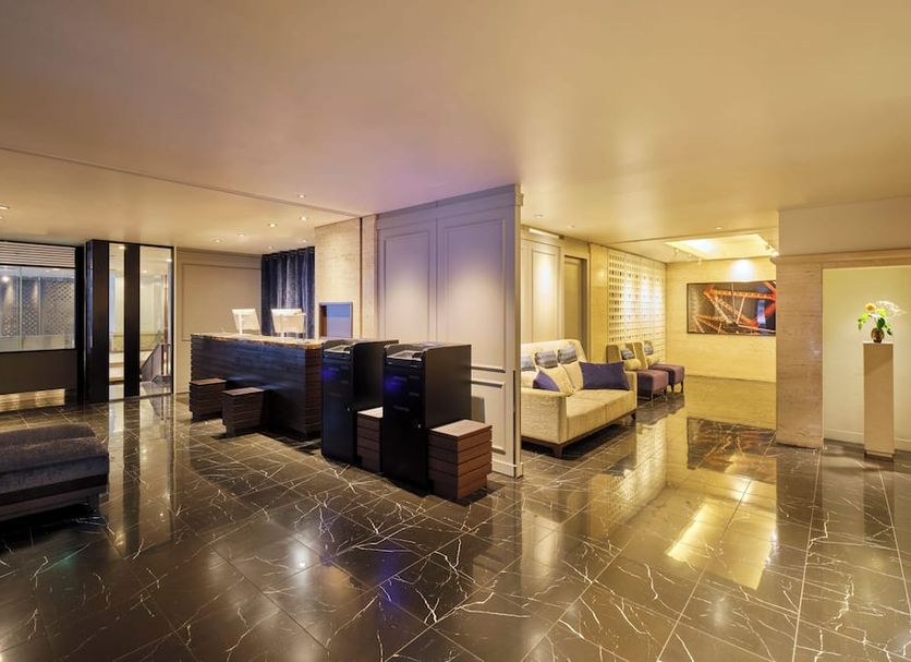 Hotel Mystays Premier Hamamatsucho in Tokyo, sleek suite with lounge seating and glossy marble floors