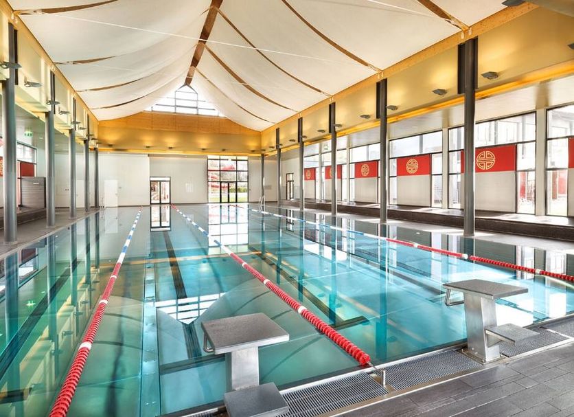 Asia Hotel & Spa Leoben indoor pool with lane markers and a high ceiling in Leoben