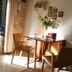 B&B Gildo Trani dining nook with wooden table, chairs, flowers, and stone accent wall