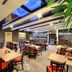Martin Hotel Prague in Prague dining room with wooden tables, red chairs and skylit ceiling