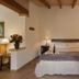 Finca Sa Carrotja, Ses Salines: cozy double bedroom with wooden beams and bedside lamps