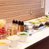Breakfast buffet at Comfort Hotel Narita in Narita with salads, fruit, eggs, and condiments on a counter.