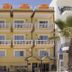 Hotel Orizzonte in Letojanni, 4-story yellow hotel facade with balconies and rooftop umbrellas