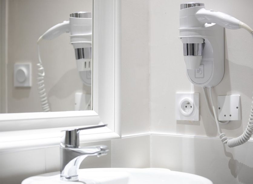 Hotel Beauvilliers in Saint-Aignan bathroom with wall-mounted hair dryer, sink and mirror