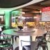 Hotel Embaixador in Porto Alegre lounge with round tables and black chairs beside a glass-walled dining area