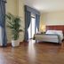 Hotel della Valle in Agrigento guest room with bed, hardwood floor, window drapes and potted plant