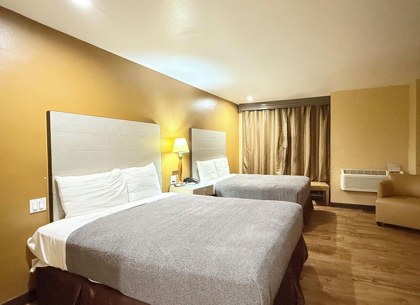 Redondo Beach Inn in Gardena: guest room with two beds, lamp lighting, chair, and window curtains