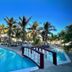 Hotel Tesoro Beach in La Herradura with a palm-lined outdoor pool and arched bridge