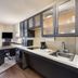 Sonesta Simply Suites Pittsburgh Airport suite kitchenette with stove, sink, microwave, and seating area