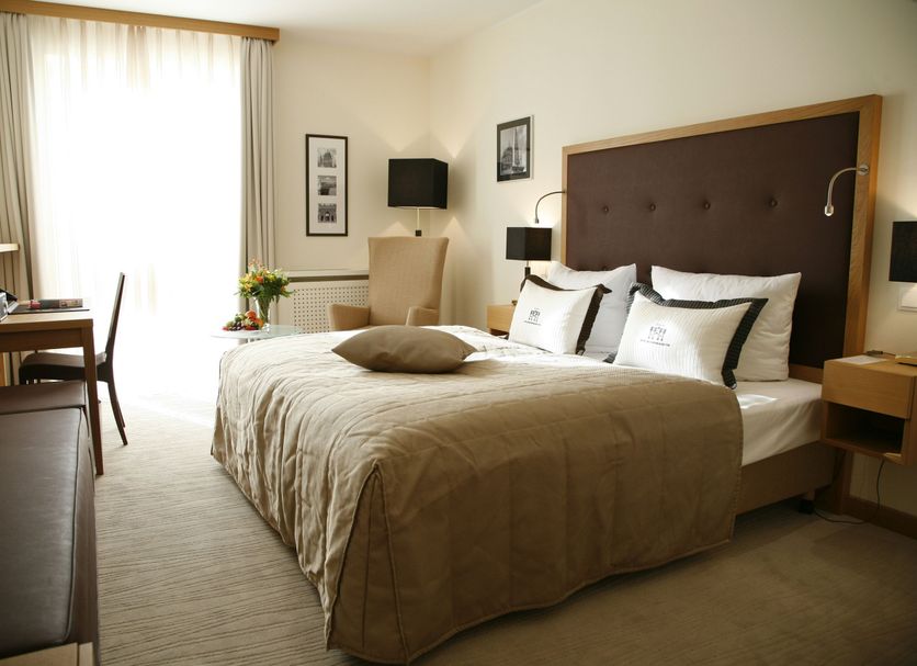 Hotel Brandenburger Tor Potsdam guest room in Potsdam with a king bed, desk, and window seating area