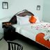 Blooming Paradise Thekkady guest room with bed, orange accents, rose petals, and sitting area