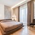 Resort Miramonti Forte dei Marmi bedroom with king bed, pendant lights, and balcony doors