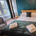 The Darnley Hotel in Ilfracombe bedroom with double bed, teal accent wall, and bay windows