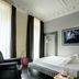 Suite Art Navona Rome room with bed, tall windows, black curtains and dark wood floor