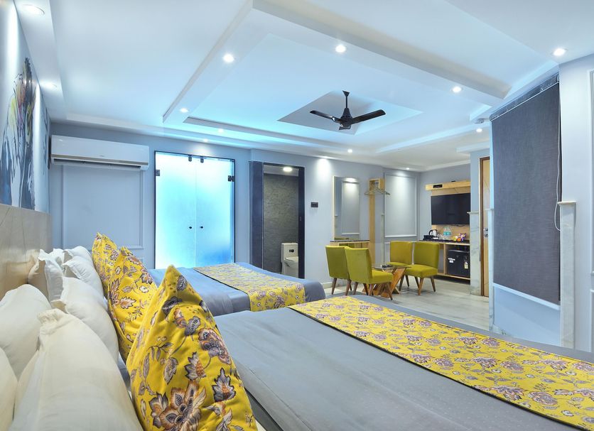 Hotel Cottage Yes Please New Delhi guest room with two beds, dining nook and modern ceiling fan