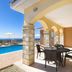 Club St. George in Paphos: covered terrace beside a pool with sea view and lounge chairs