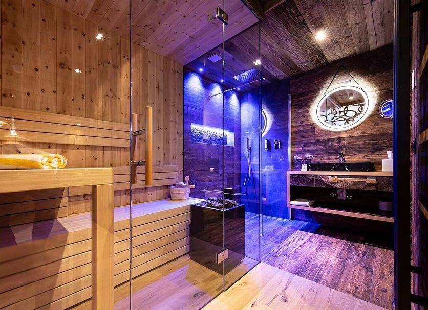 Hotel Arkadia in Corvara in Badia: wood-paneled sauna with glass steam shower and spa seating
