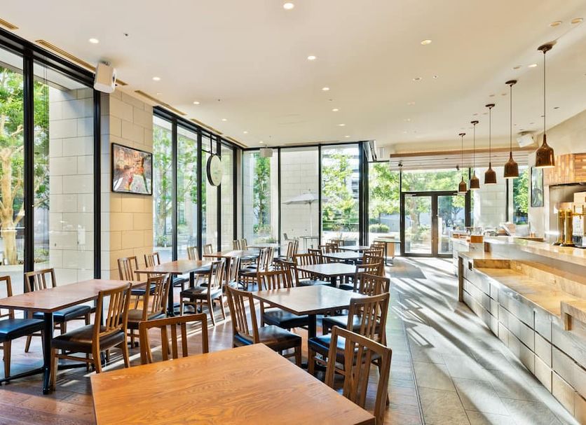 Mitsui Garden Hotel Kashiwa-No-Ha restaurant with large windows, wooden tables and chairs in Kashiwa