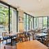 Mitsui Garden Hotel Kashiwa-No-Ha restaurant with large windows, wooden tables and chairs in Kashiwa